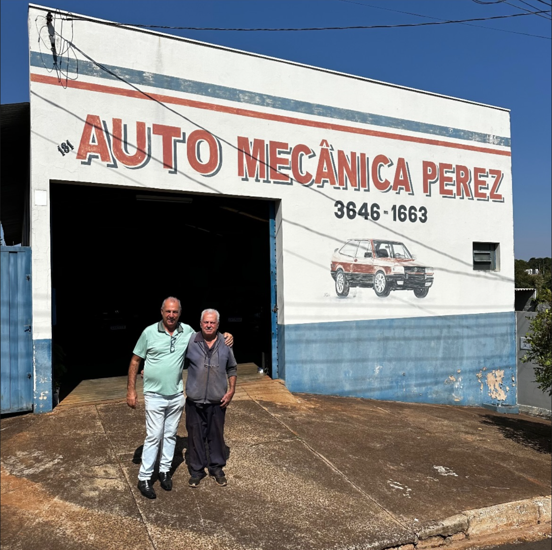 Foto de arquivo da fachada original da Auto Mecânica Perez, com o telefone antigo pintado na parede